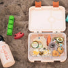 Ilyass Peach Stainless Steel Water Bottle on sand next to Ilyass customized Bento Lunch Box from Kiddy Planer